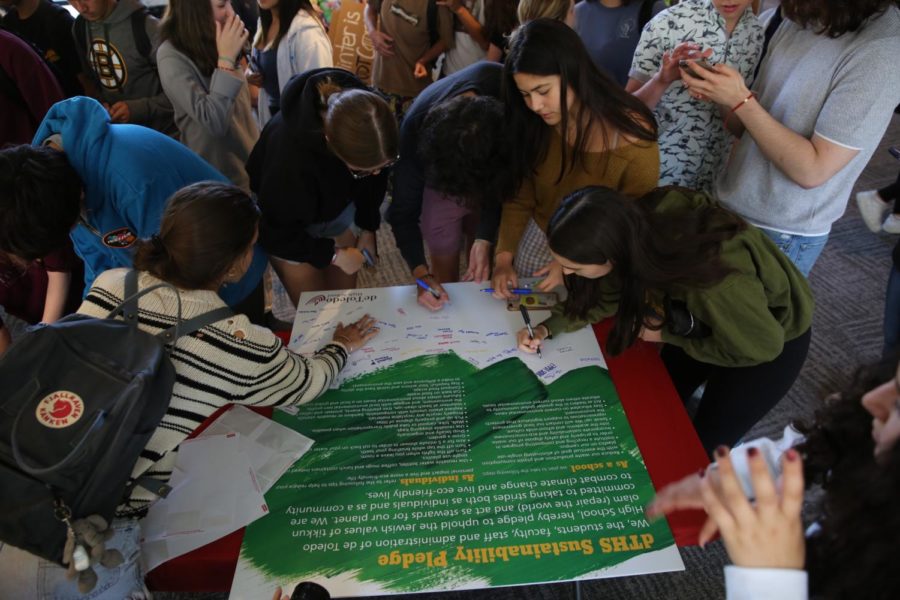 Students sign a sustainablility pledge to be more environmentally friendly in a school-wide effort to combat the effects of climate change.