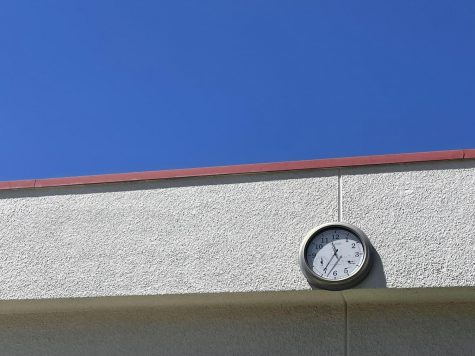 During the first week of school, I took this picture of a clock in the quad area in front of a cloudless sky. The wall holding the clock looks as if it is connected to the sky.  With the solid blue color of the sky, it looks like it was painted on. 