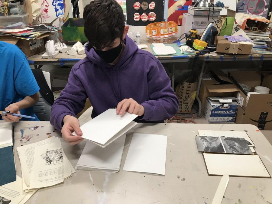 Sam K (25) works on his book project in the art room May 25, 2022.