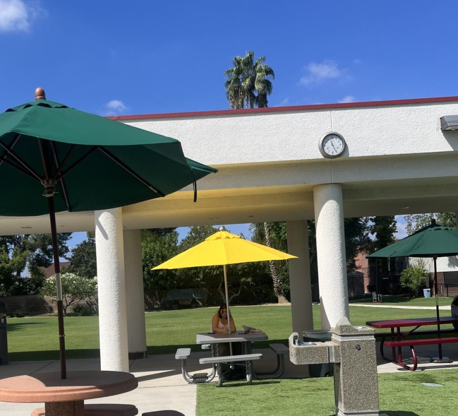 The vibrant yellow umbrella stands out from the rest of the umbrellas, representing joy and a new beginning. Pictured during the first week of school, this student works at one of the new tables located throughout the courtyard.