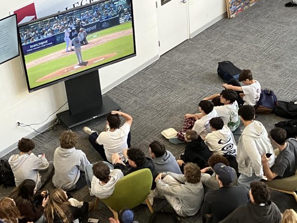 Baseball fans gather around the large screen in the de Toledo lobby during lunch break Oct. 14 to watch the Dodgers beat the Mets 7-3.