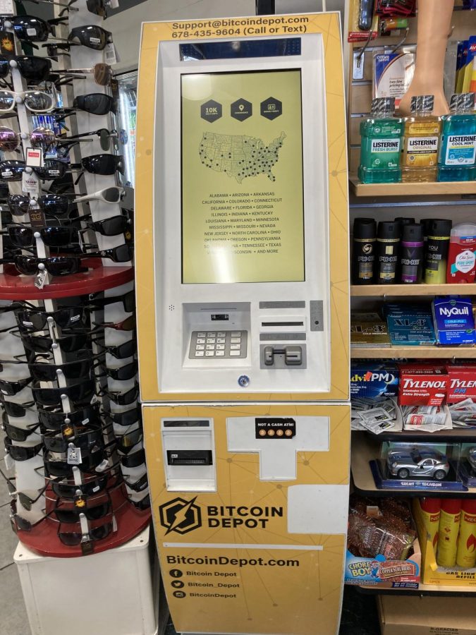 A Bitcoin machine joins the rack of sunglasses and rows of sundries at a local gas station mini-mart.