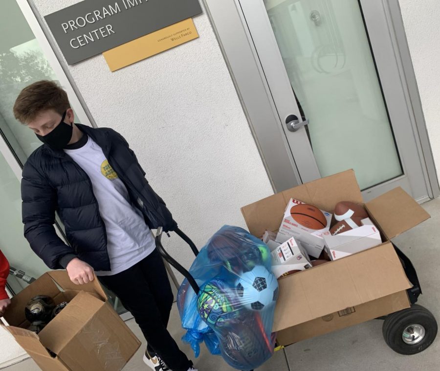 Presidential Service Award winner Matthew L. ('22) helps unload brand new sporting equipment just in time for the holiday season at LA Family Housing. 