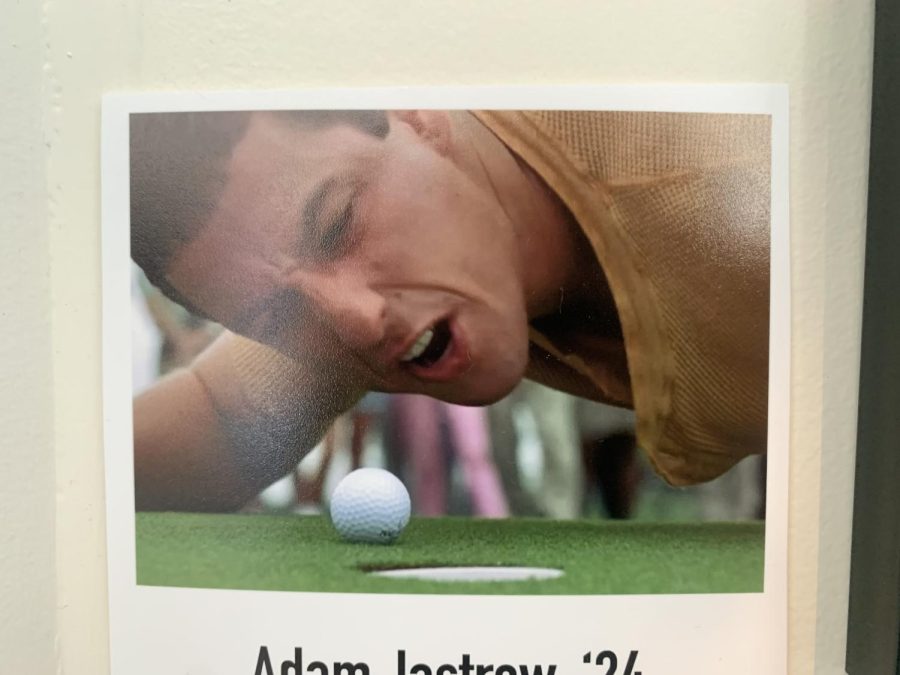 Adam J. (24) exhibits a photograph of a still from the Adam Sandler movie Happy Gilmore.