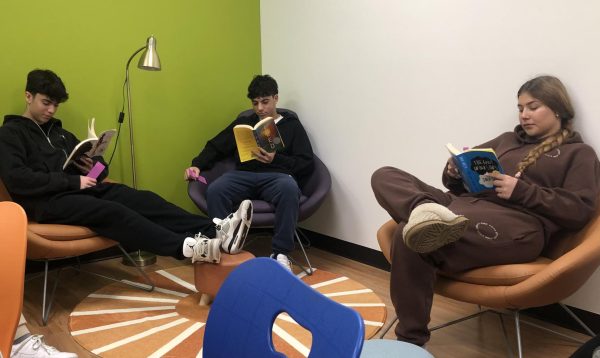 Sophomores Ethan N., Yotam G., and Shira L. read books quietly in The Den. de Toledos new library is a space where students can go to study quietly, check out books and relax.