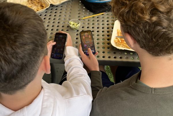 Noah F. ('28) and Max M. ('28) bond over a mobile game together during lunch.