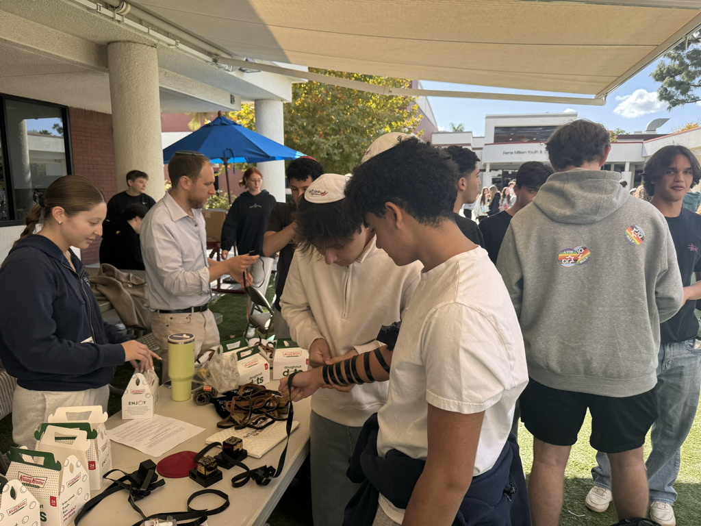 Tohar L(25), and Jonah B (26), wrap tefelin at the mental health fair on Friday Nov. 15. As Nicole A (25), Rabbi Greenfield, were there to help answer questions and assist others. 