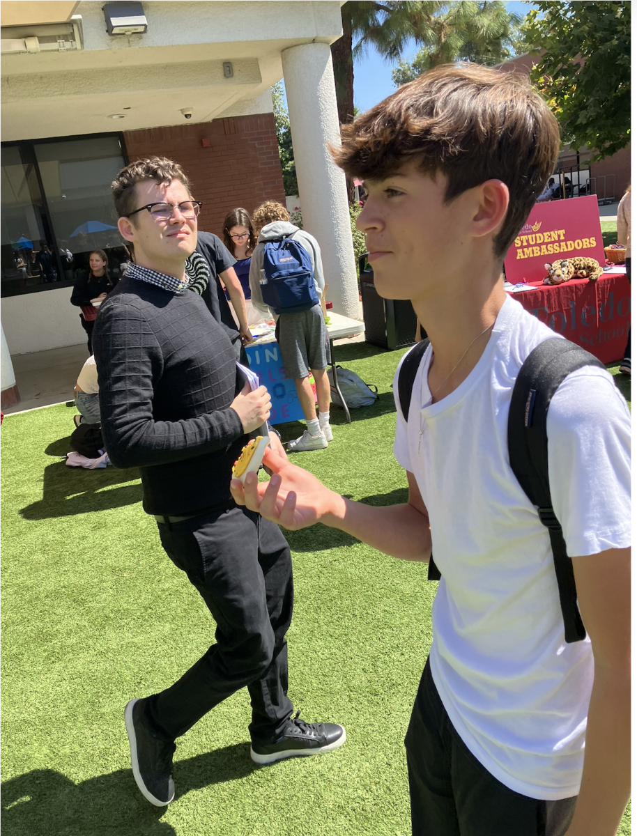 Sammy M. ('28) walks around dTHS club fair eating a cookie from a stand on Sept. 25, 2024.