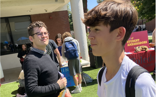Sammy M. ('28) walks around dTHS club fair eating a cookie from a stand on Sept. 25, 2024.