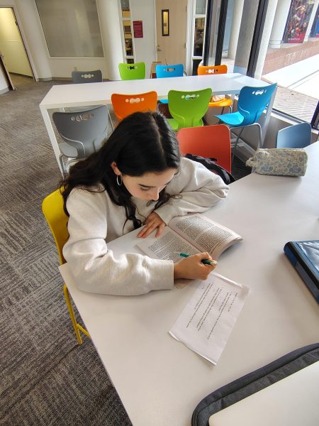 Lielle A. ('28) reading her book that was assigned as English homework.