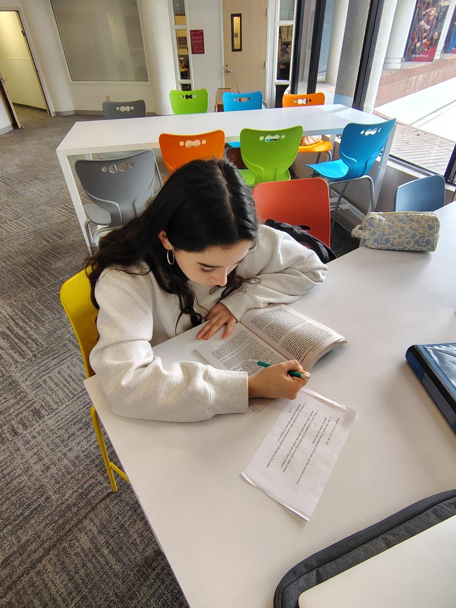 Lielle A. ('28) reading her book that was assigned as English homework.
