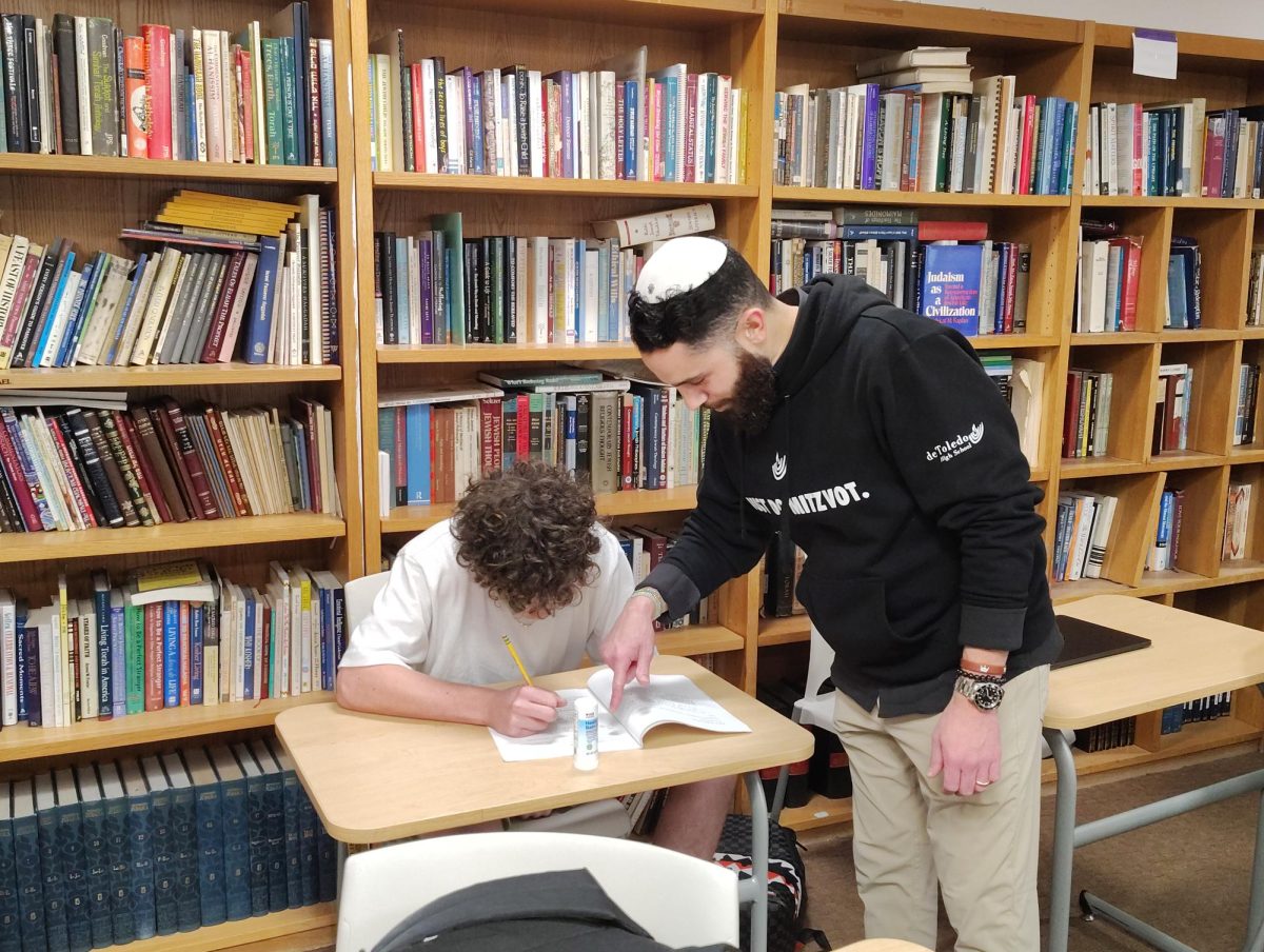 New Judaic studies teacher, Rabbi Wasserman helping a student with classwork.