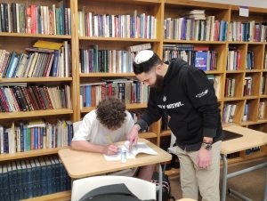 New Judaic studies teacher, Rabbi Wasserman helping a student with classwork.