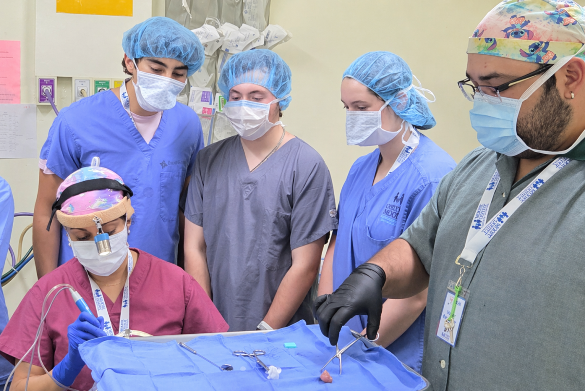 three dTHS students watching doctors in the operating room during the Guatemala ENT Medical Mission