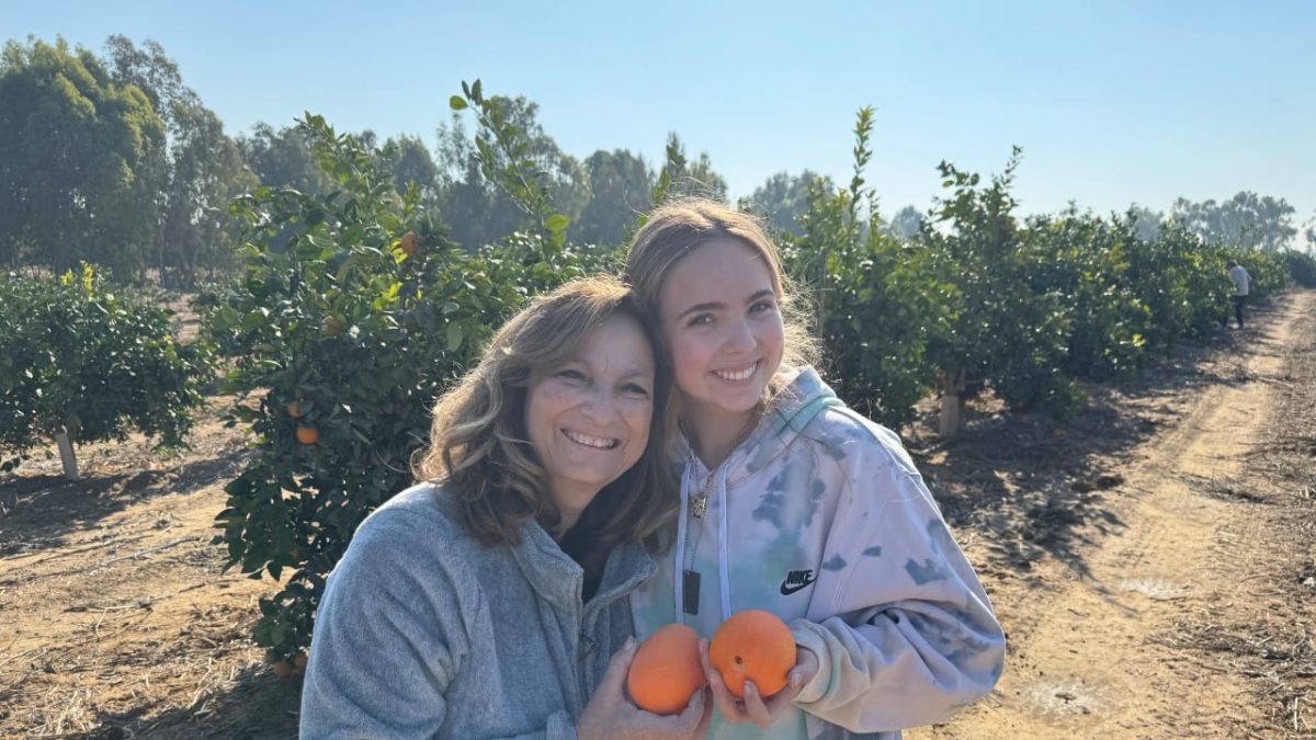 The Writer picks oranges on Kibbutz Be’eri with her grandmother Linda Lebovitz.
